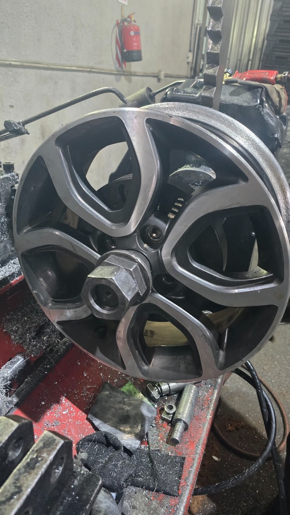 Machinist operating CNC wheel lathe
